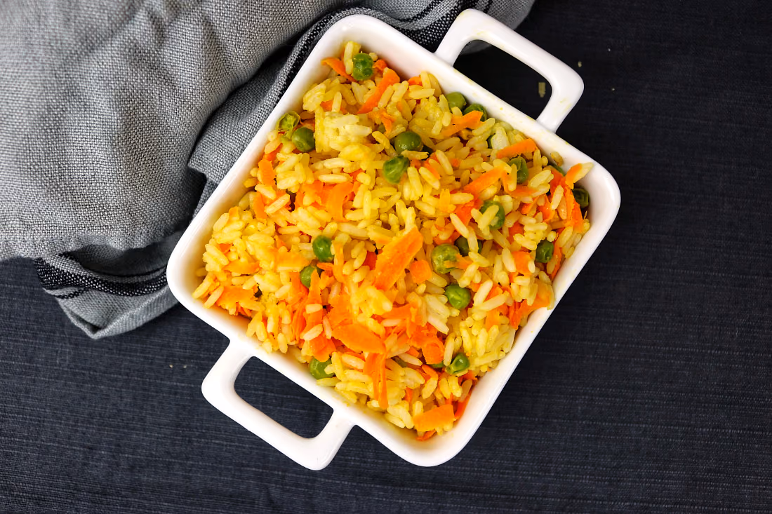 Arroz primavera com cenoura e ervilhas, numa travessa branca